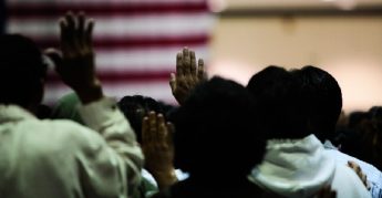 Immigrants of many ethnic backgrounds appear at a swearing in ceremony for US citizenship