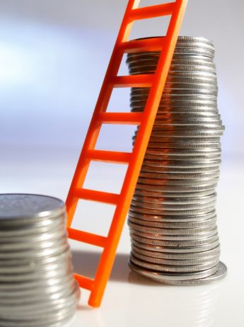 Small toy ladder leaning against stacked coins