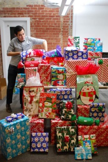 Sponsor organizing stack of Christmas gifts