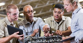 Instructor que muestra a los estudiantes cómo reparar un motor.