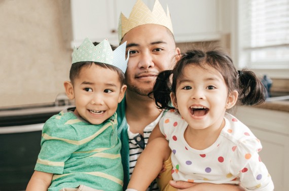 Young male with a little boy and girl wearing crowns