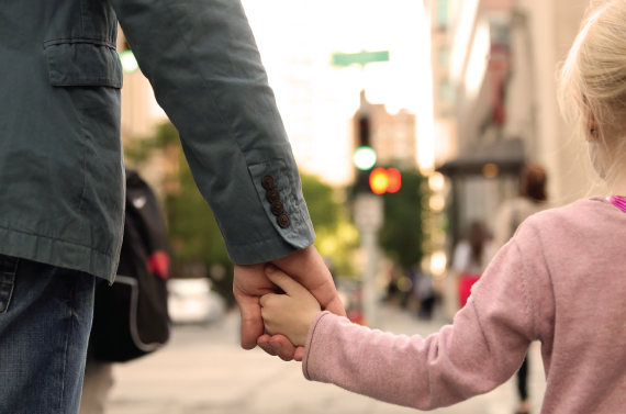 An adult and little girl holding hands