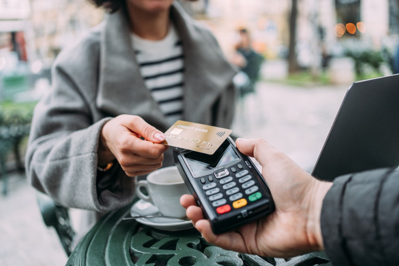Una cliente que realiza pagos inalámbricos o sin contacto con tarjeta de crédito o débito.